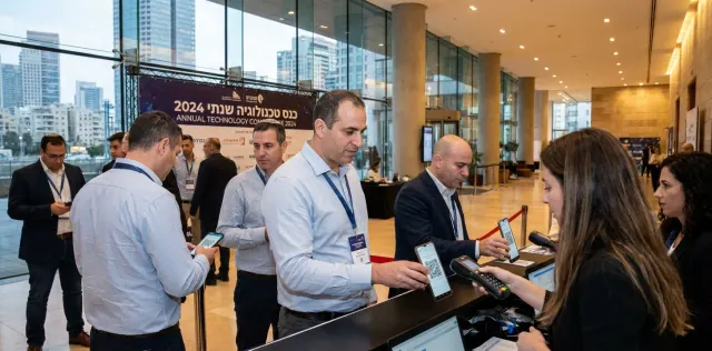 לובי כנס עם משתתפים סורקים קודי QR מהטלפון שלהם בדלפק הרישום
